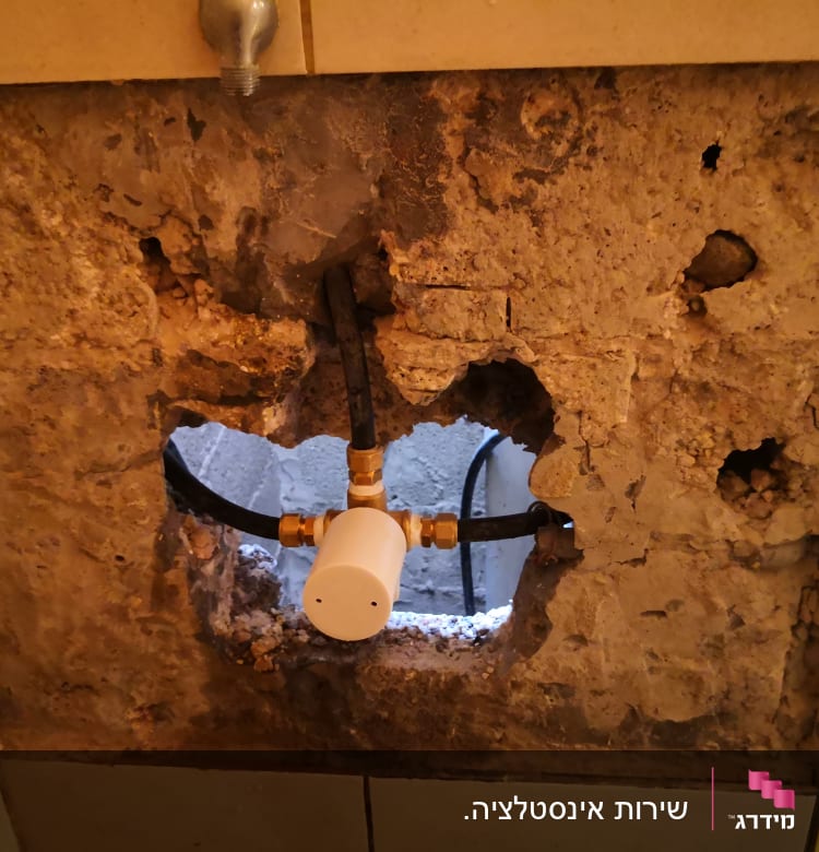 צינור מים עם מחבר בקיר חשוף